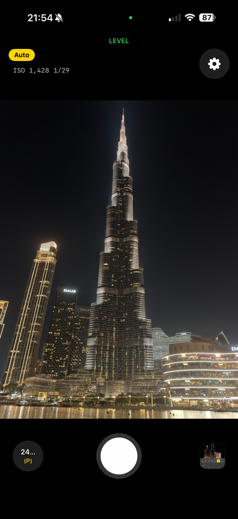 Acetate camera viewfinder shooting the Burj Khalifa at night with live ISO and shutter readouts, level confirmation, and Auto mode badge