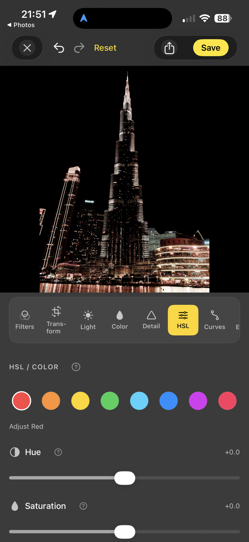 Acetate editor's HSL tab adjusting Red Hue and Saturation on a night photo of the Burj Khalifa, with all eight colour-range circles visible in a row
